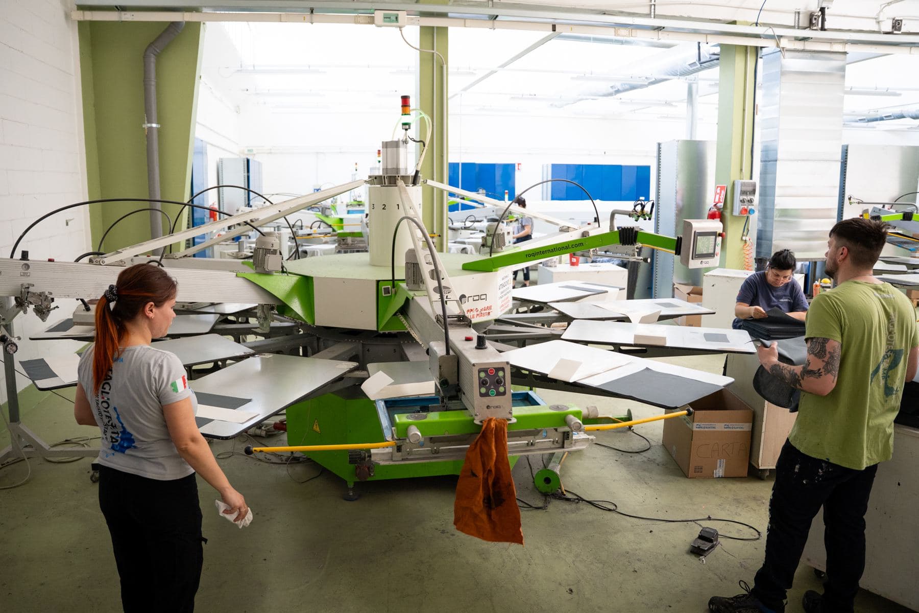 Operatori al lavoro sulla macchina per serigrafia