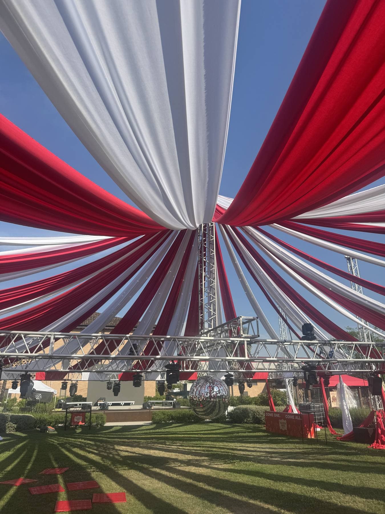 Tendone per evento con drappeggi in tessuto rosso e bianco